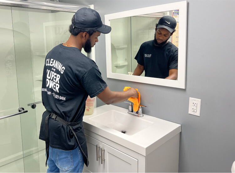 Cleaning technician wiping bathroom faucet